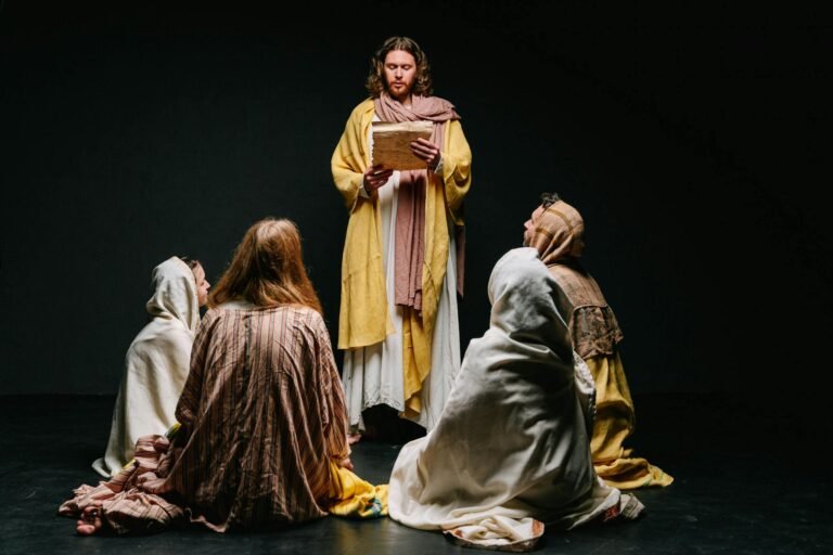 A theatrical scene depicting a group dressed in biblical costumes, set on a dark stage.